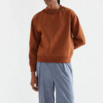 Brown crew-neck sweatshirt with amber jeweled collar detail and ribbed trims