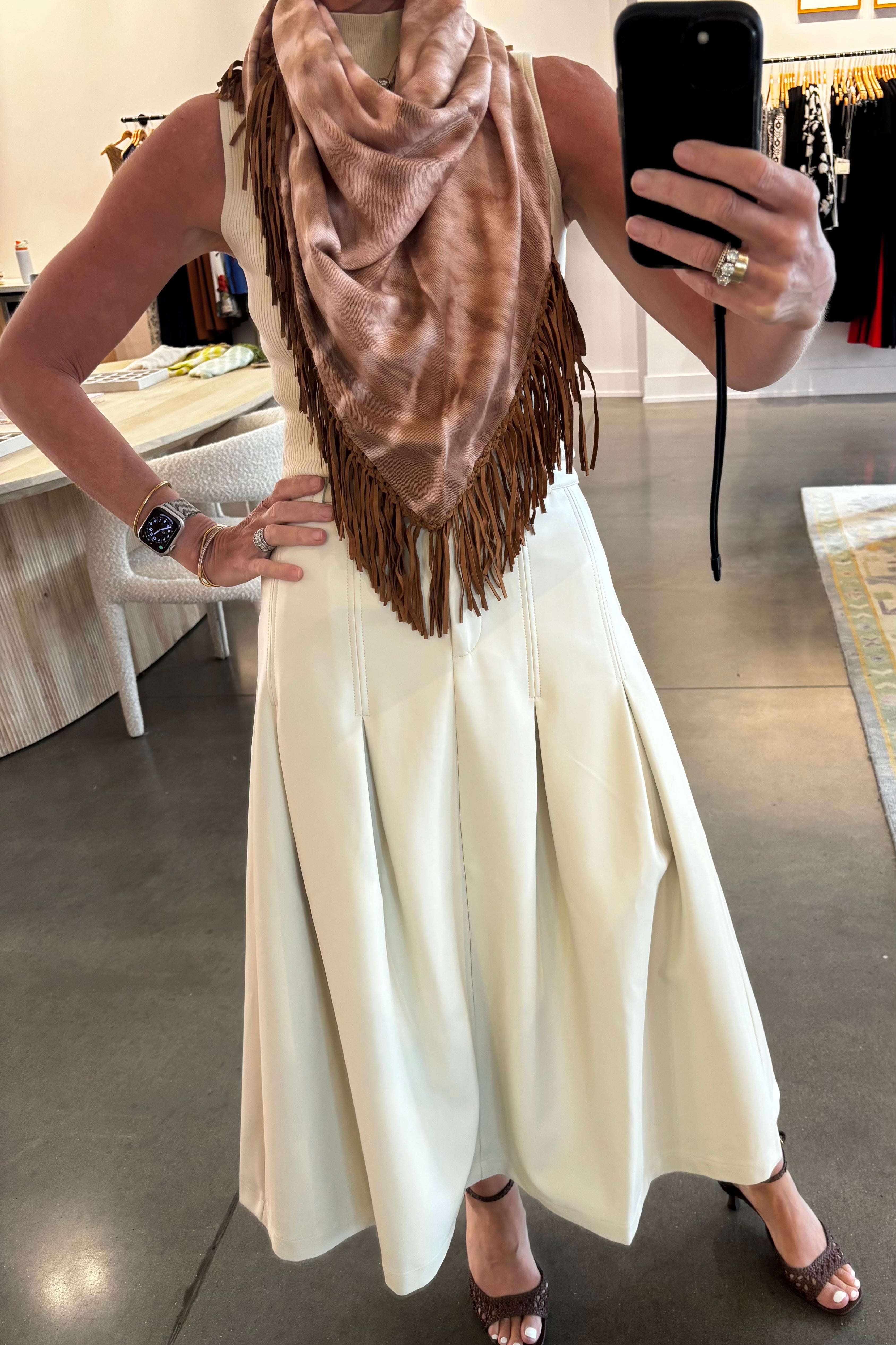 Tan tie-dye pashmina scarf with brown leather fringe trim, styled as neckerchief
