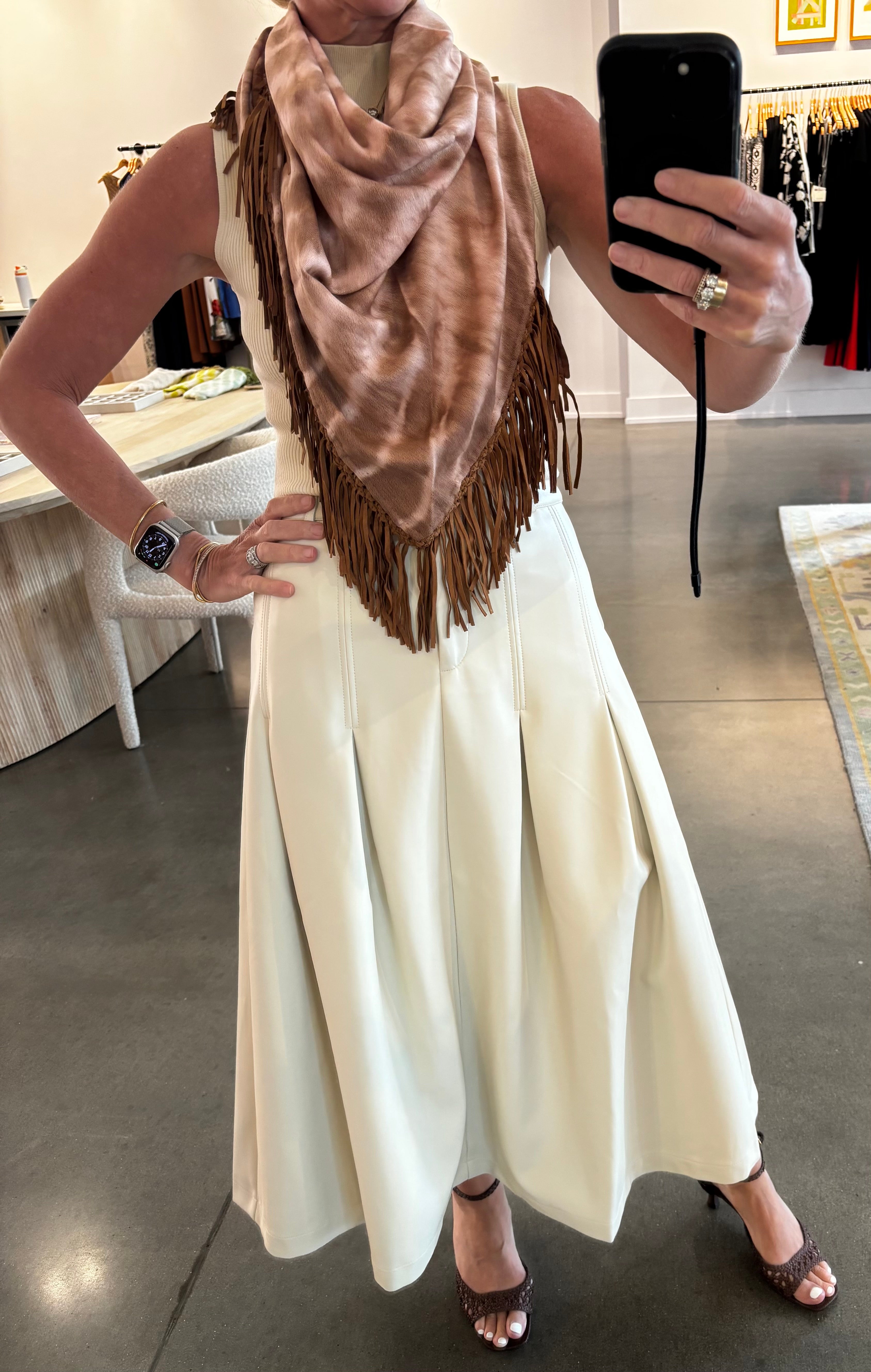 Tan tie-dye pashmina scarf with brown leather fringe trim, styled as neckerchief