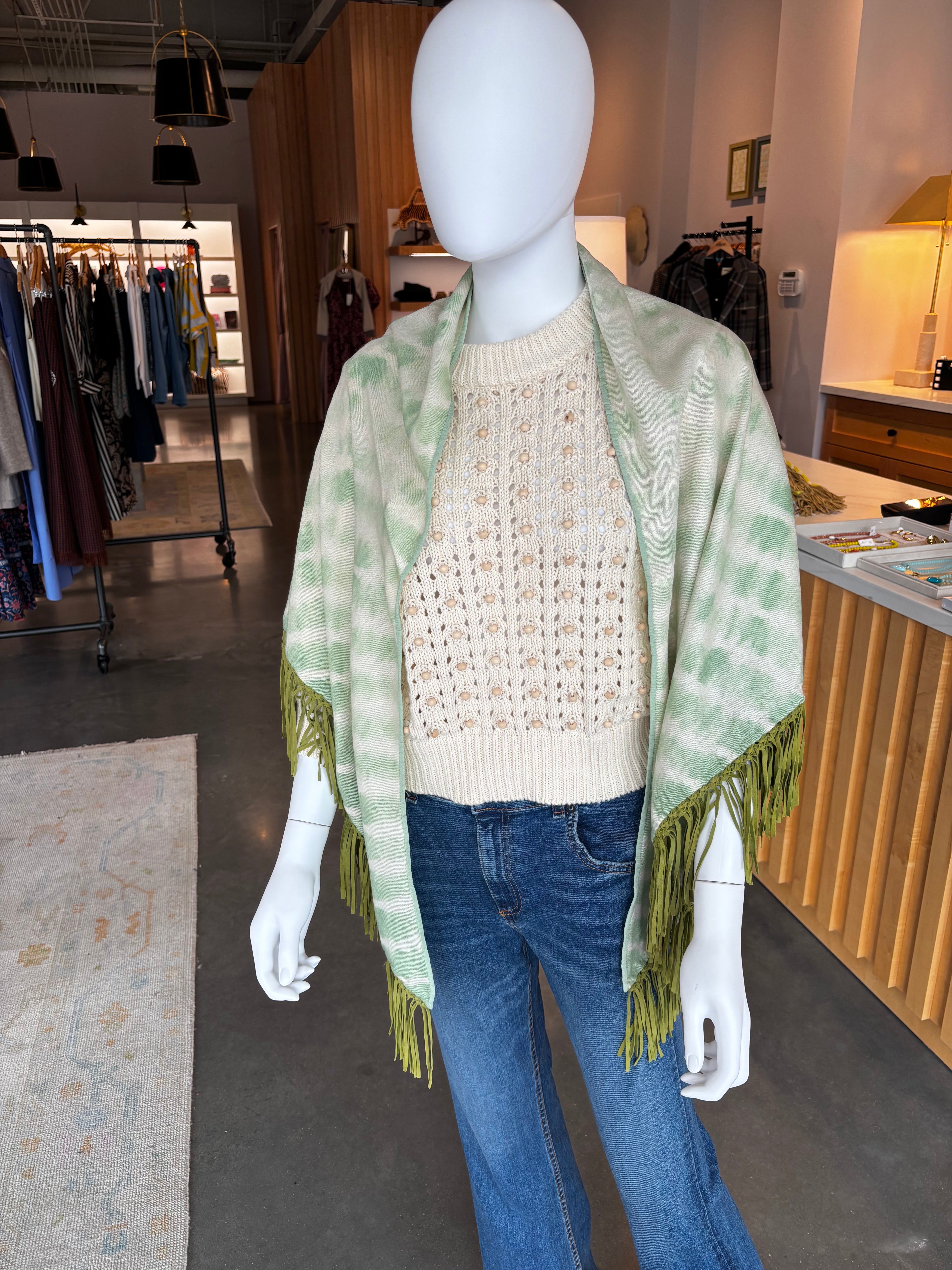 Green and white tie-dye pashmina wrap with green fringe trim on mannequin