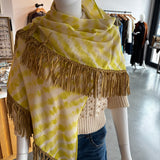 Yellow tie-dye pashmina wrap scarf with tan leather fringe trim on mannequin