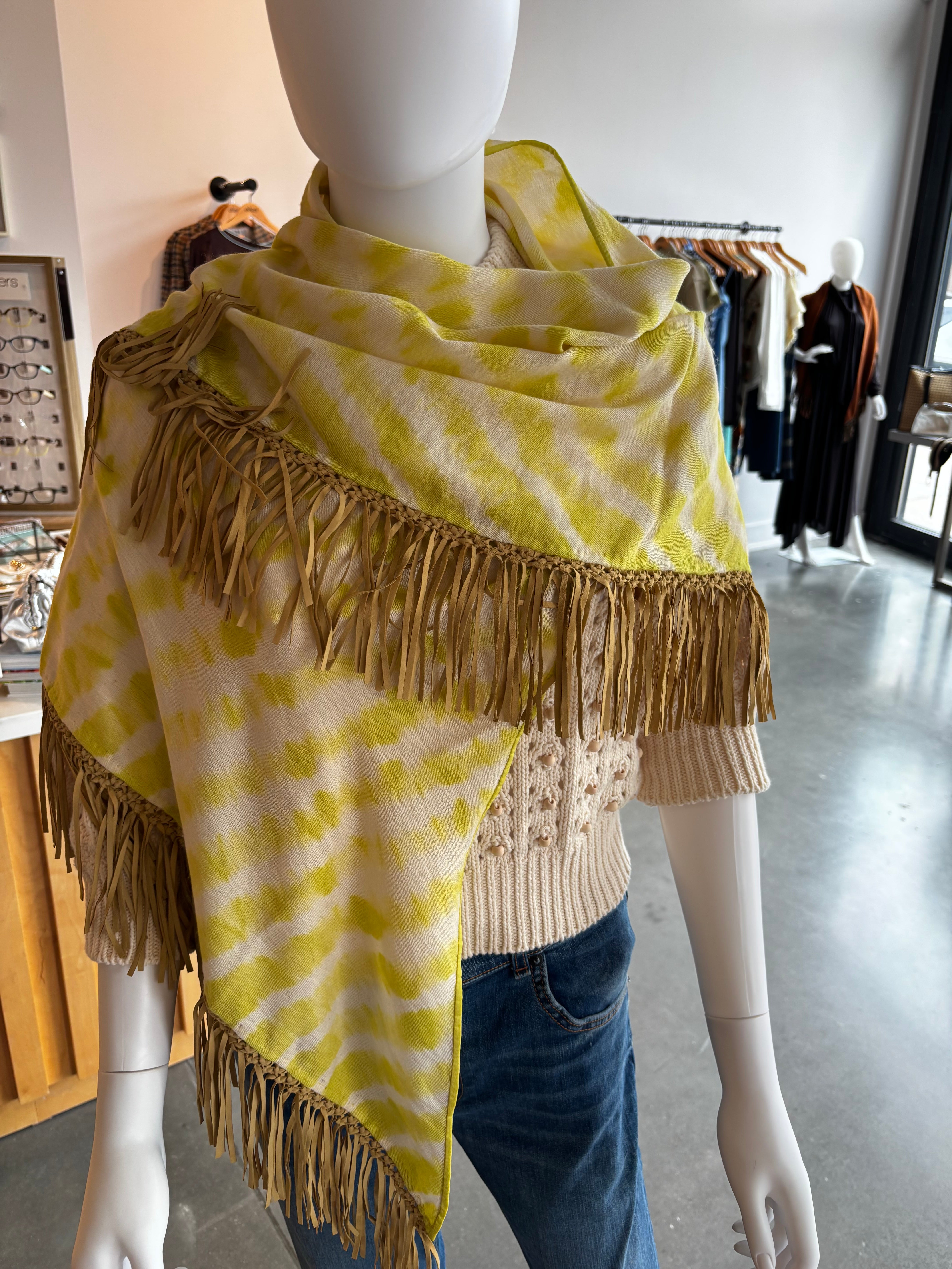 Yellow tie-dye pashmina wrap scarf with tan leather fringe trim on mannequin