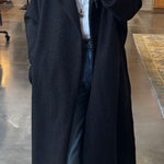 Black boucle longline overcoat worn open over white shirt and jeans