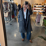 Gray long reversible parka coat with faux fur lining, worn open over jeans