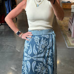 Blue floral wrap midi skirt with wide waistband and belt, paired with cream ribbed top