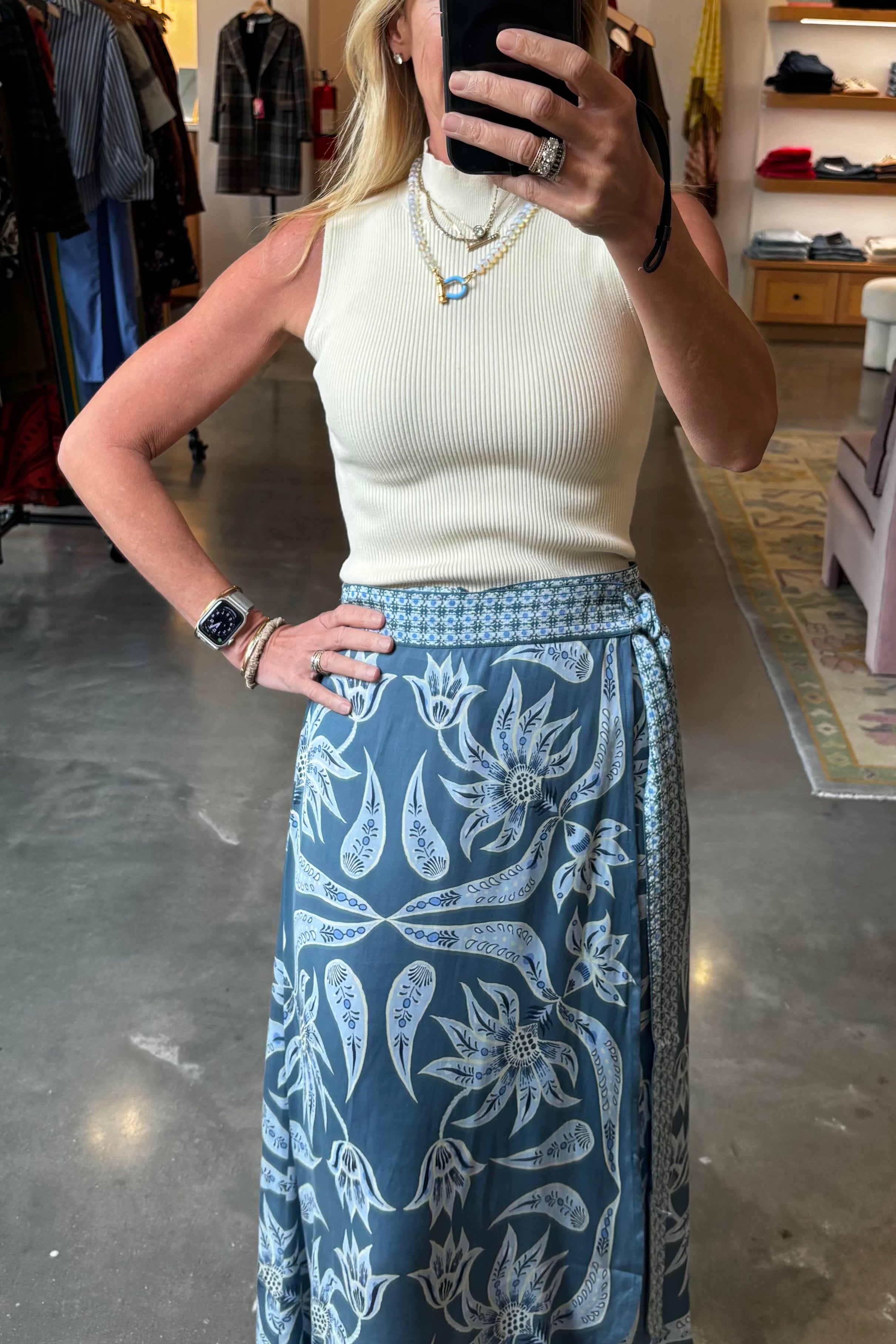 Blue floral wrap midi skirt with wide waistband and belt, paired with cream ribbed top