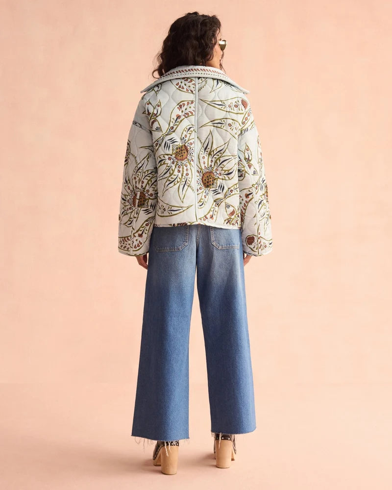 Omika Goldie quilted floral jacket in light blue worn with wide-leg jeans, back view
