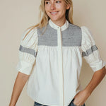 White cotton poplin blouse with navy smocked yoke and ruched puff sleeves