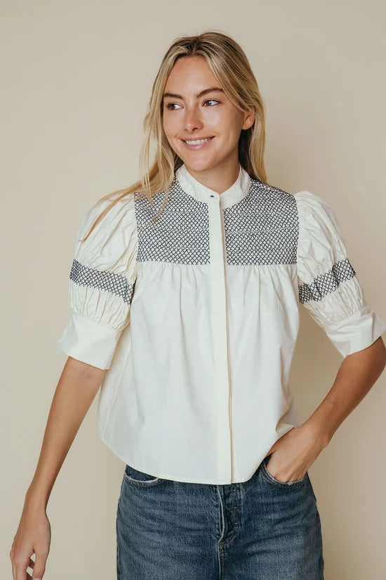 White cotton poplin blouse with navy smocked yoke and ruched puff sleeves