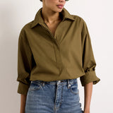 Cropped olive green cotton shirt with collar and hidden button placket paired with blue jeans
