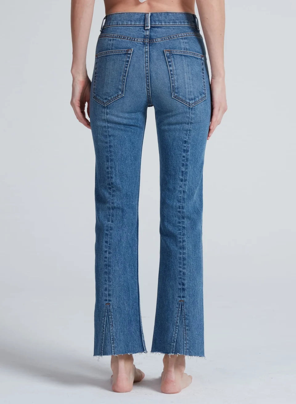 ASKK NY Split Boot Phoenix Jeans in medium blue denim, back view with raw hem slits
