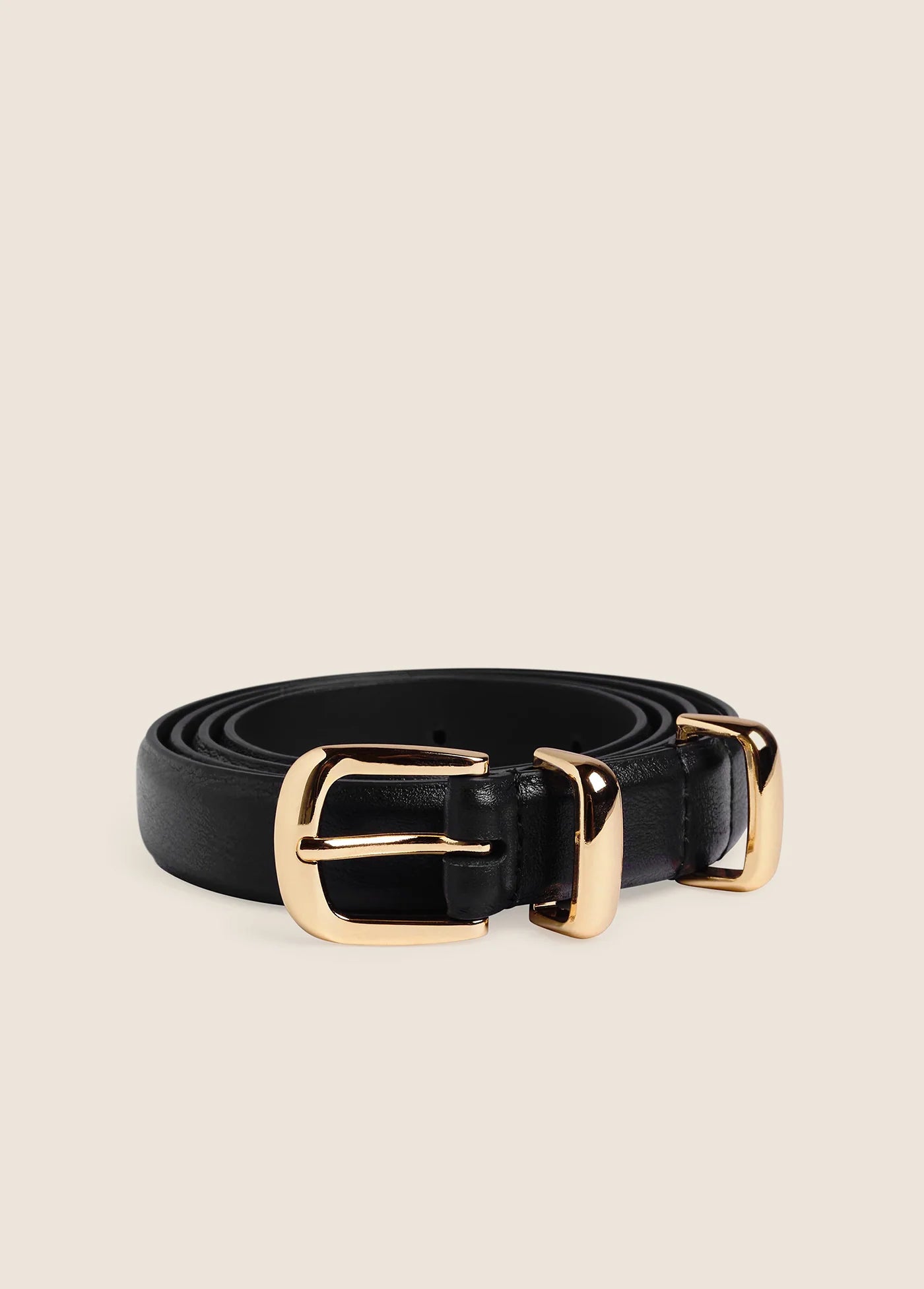 Skinny black leather belt coiled with polished gold buckle and keeper loop