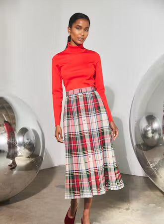 Pleated plaid midi skirt with red turtleneck top and gold front buttons