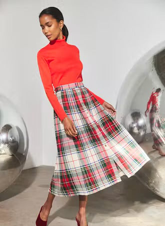 Midi-length pleated plaid skirt in red, white, and green tartan pattern