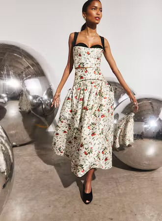 White floral midi skirt with black waistband, full silhouette, worn with matching bustier top