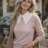 White pointed detachable collar styled over a blush pink sweater on a woman