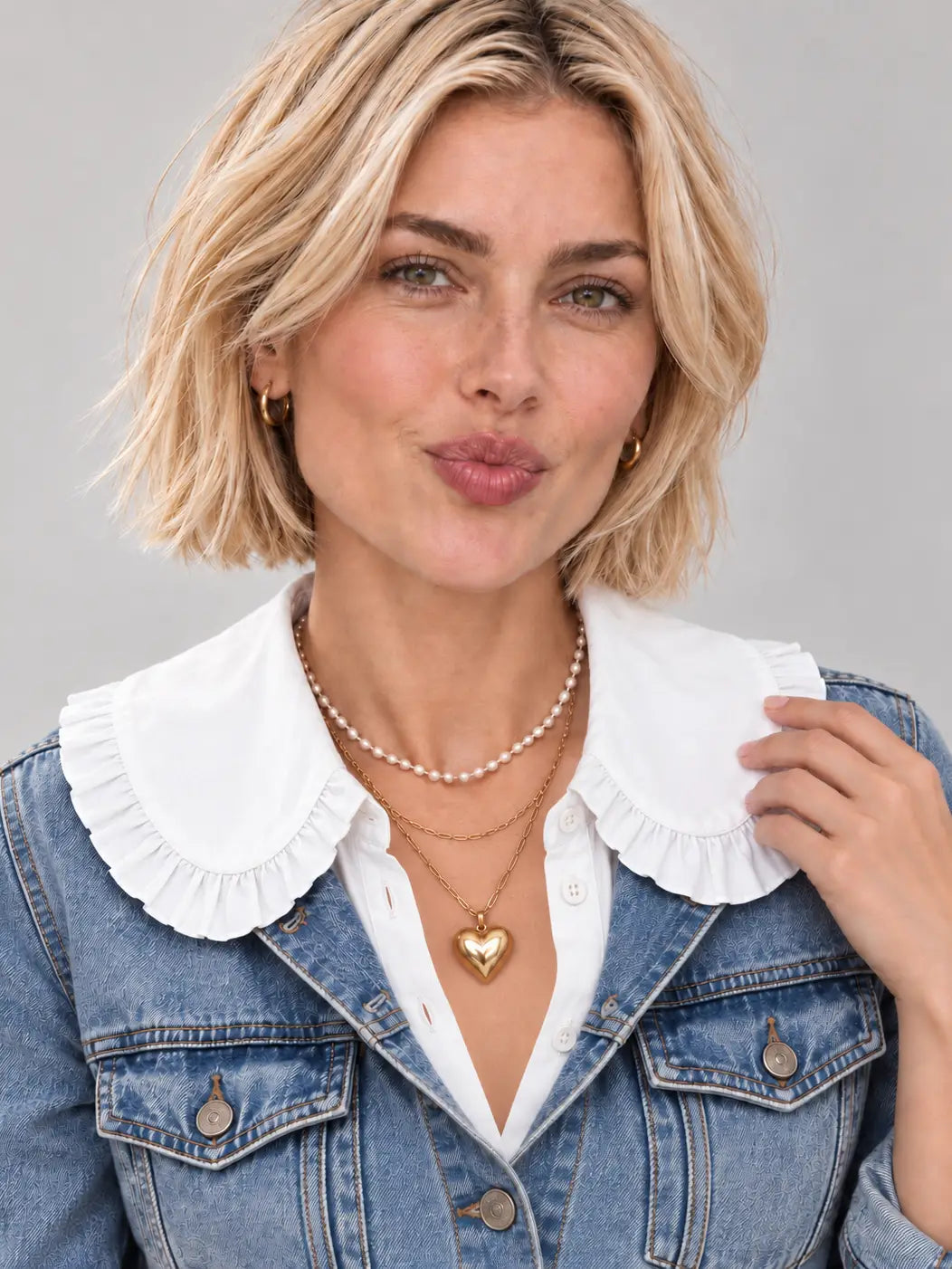 White oversized ruffle peter pan collar bib with button-front detail, worn layered
