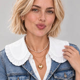 White oversized ruffle peter pan collar bib with button-front detail, worn layered
