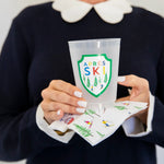 Ski Resort cocktail napkins with colorful skier and pine tree print, held with après ski cup