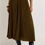 Olive green pleated midi skirt with black elastic waistband, styled with black knee-high boots