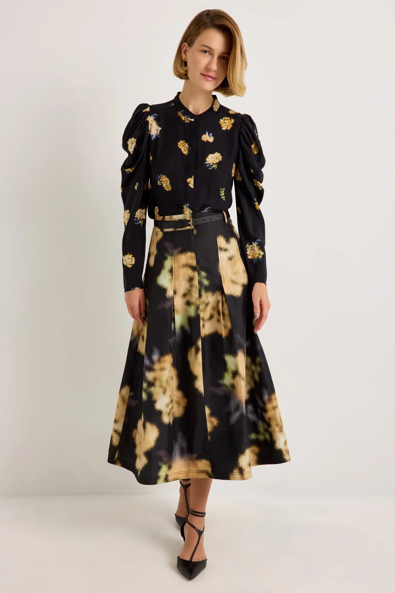 Black midi skirt with abstract yellow floral print, box pleats, and belt loops