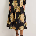 Black midi skirt with blurred floral print, pleats, and black leather belt