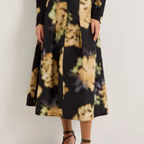 Black midi skirt with blurred floral print, pleats, and black leather belt