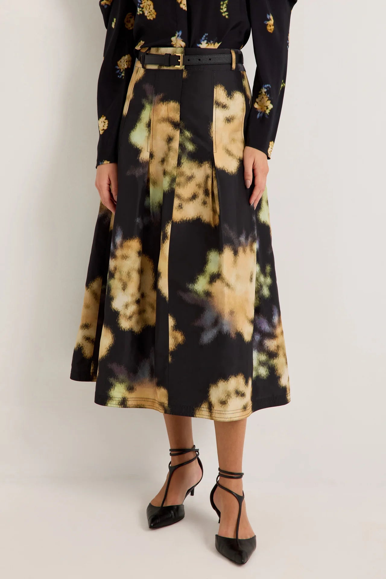 Black midi skirt with blurred floral print, pleats, and black leather belt