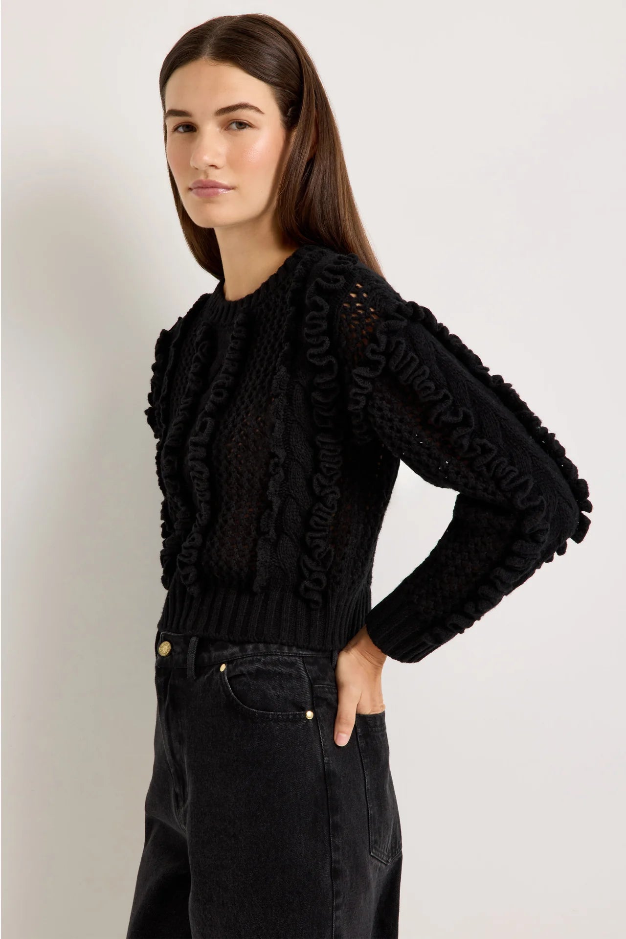 Black cable-knit wool crewneck sweater with ruffle trim accents and ribbed cuffs