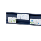 Navy blue mahjong tile rack holding floral and numbered white mahjong tiles
