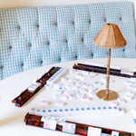 Set of four tortoise shell acrylic mahjong racks with white tiles on a white table