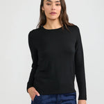 Women's black long sleeve crew neck fitted T-shirt paired with dark blue jeans