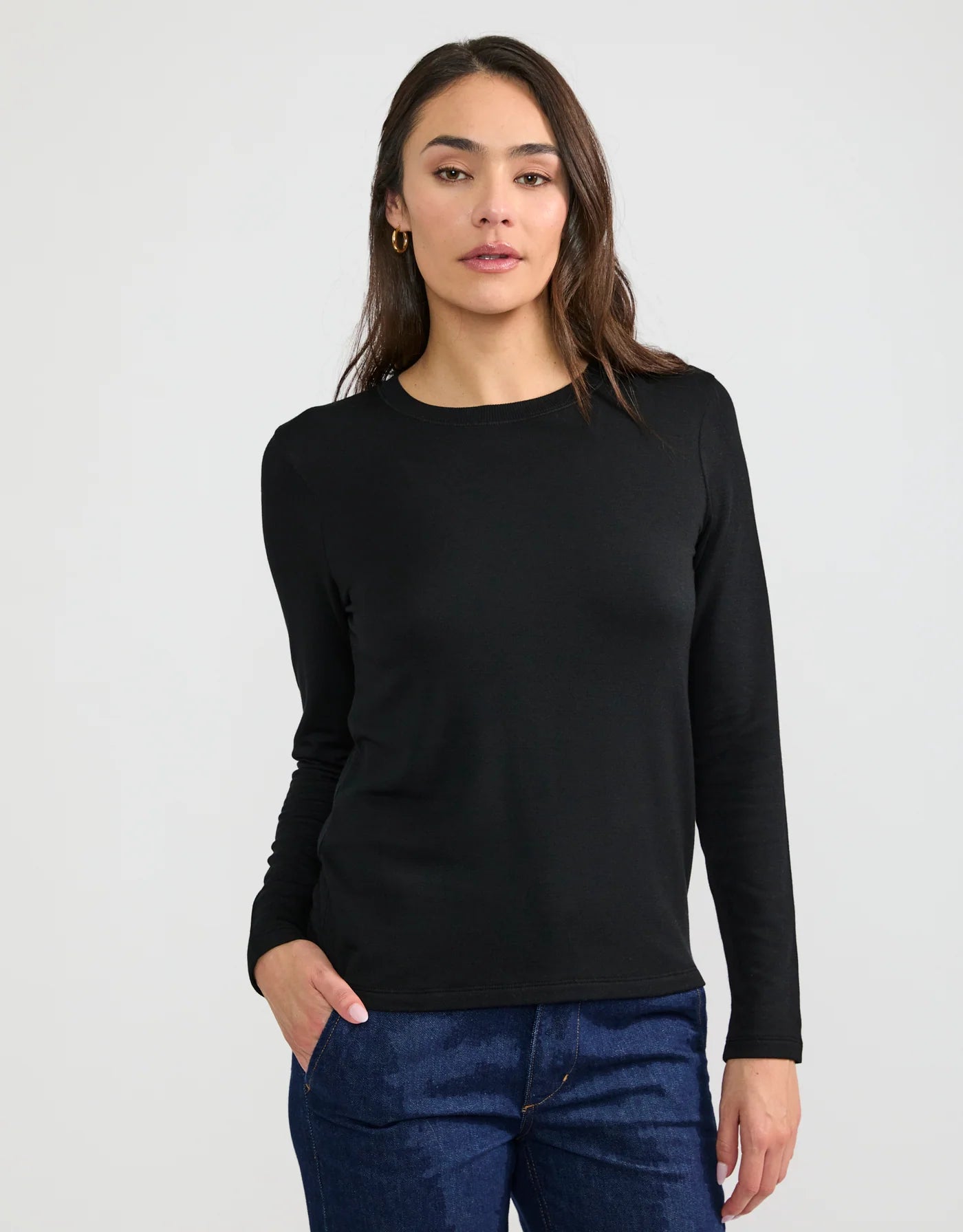 Women's black long sleeve crew neck fitted T-shirt paired with dark blue jeans