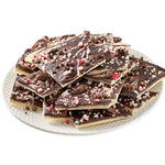 Bissinger peppermint cookie bark pieces piled on white plate with crushed candy cane topping