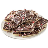 Bissinger peppermint cookie bark pieces piled on white plate with crushed candy cane topping
