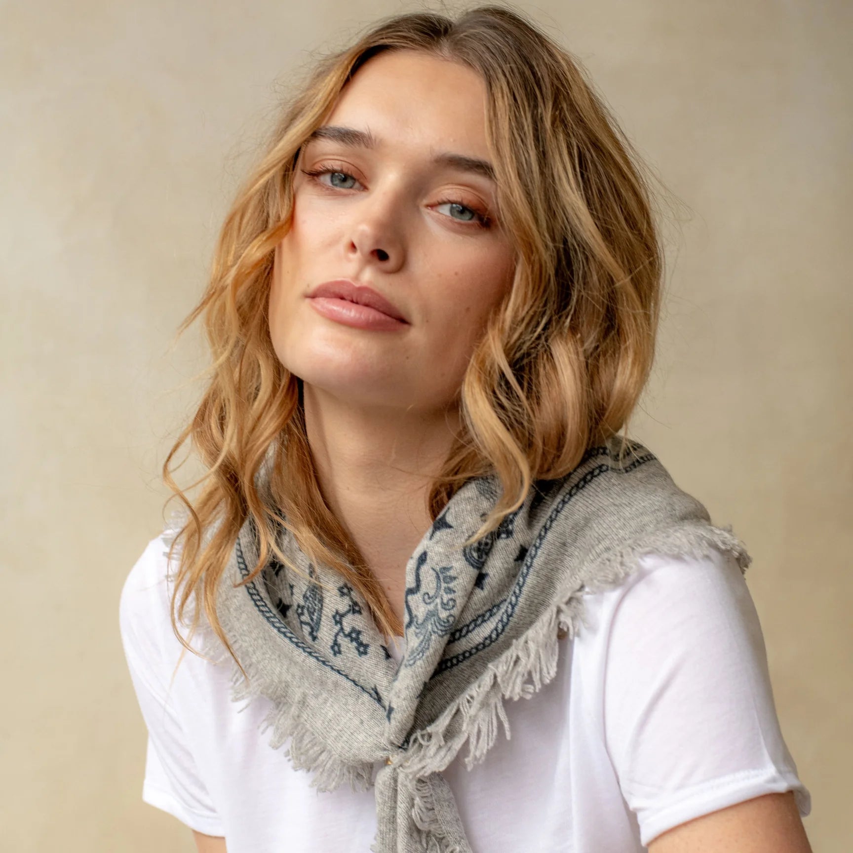 Grey cashmere bandana wrap with navy celestial bird pattern and fringe edges