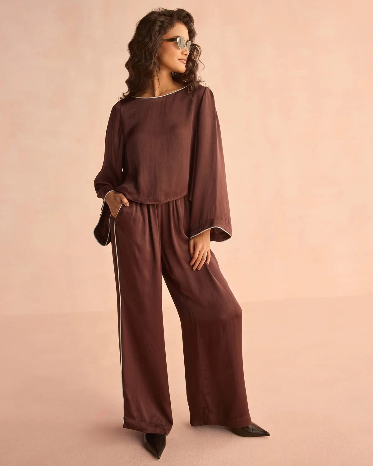 Women's brown long-sleeve blouse with white piping trim and wide cuffs