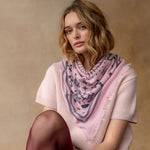 Pink cashmere bandana wrap with celestial bird print worn around neck