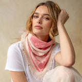 Pink cashmere bandana wrap with celestial bird print and fringe edges